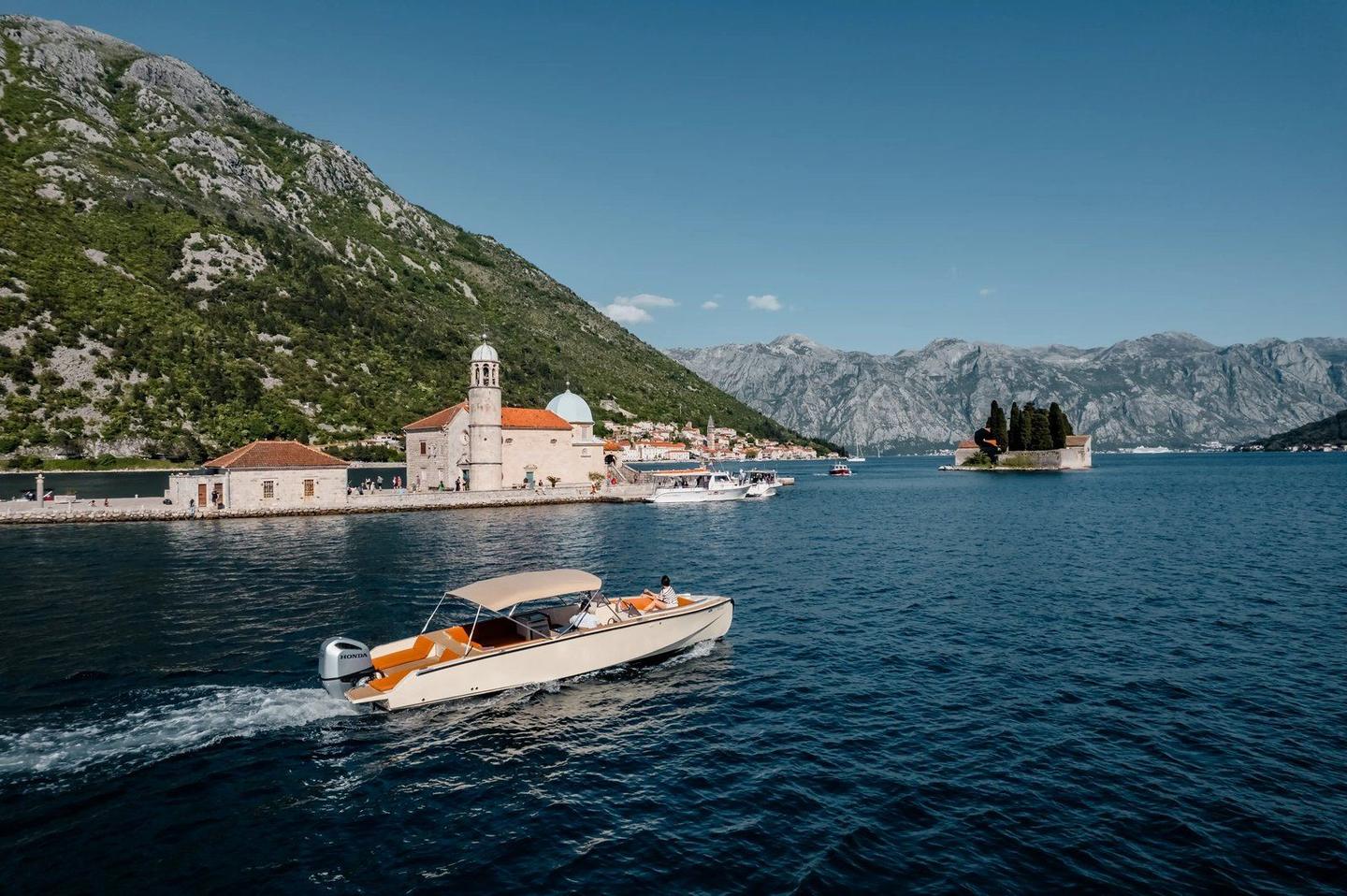 A speedboat cruising past Our Lady of the Rocks